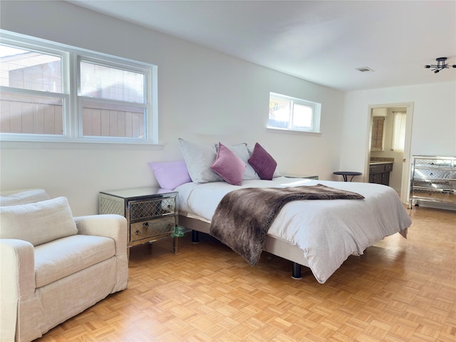 bedroom featuring visible vents and connected bathroom