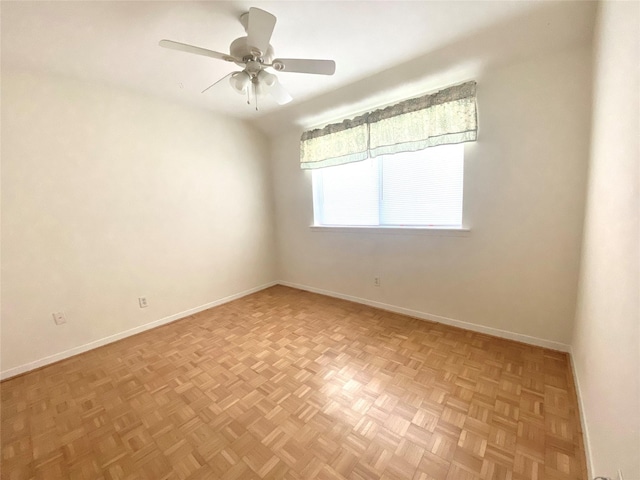 spare room with ceiling fan and baseboards