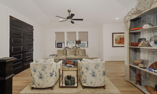 living room with light hardwood / wood-style floors and ceiling fan