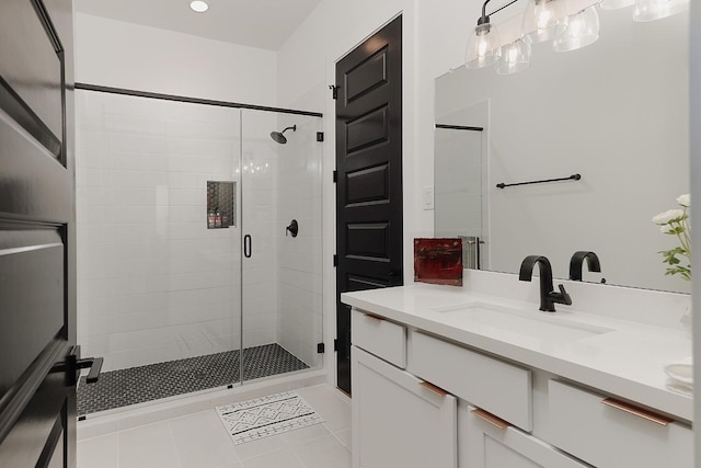 bathroom featuring tile patterned flooring, vanity, and a shower with door