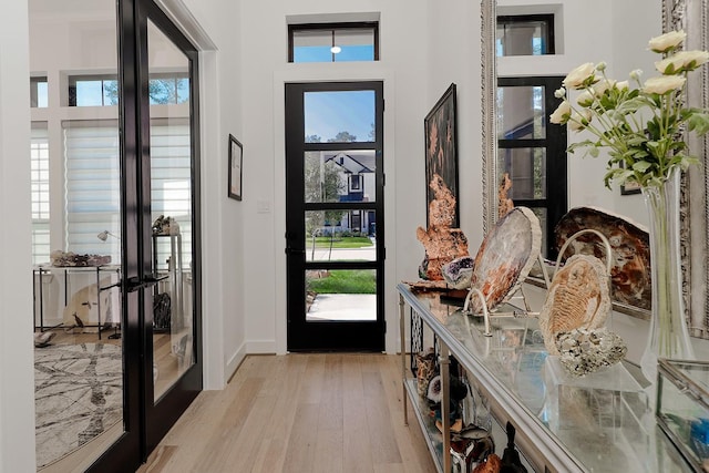 foyer entrance featuring french doors and light hardwood / wood-style floors