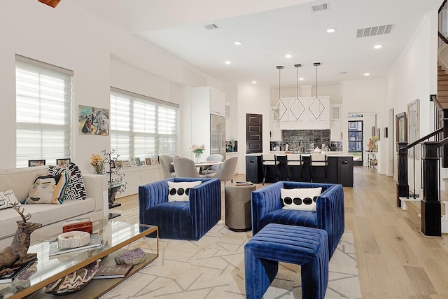 living room with light hardwood / wood-style floors and sink