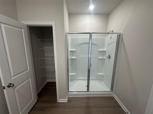 bathroom with hardwood / wood-style flooring and walk in shower