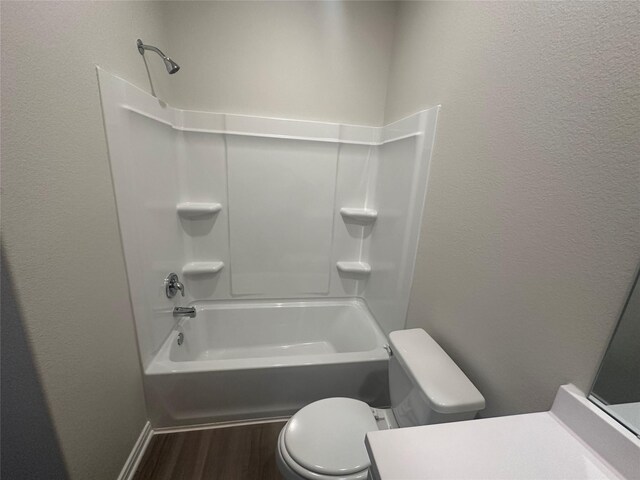 full bathroom with hardwood / wood-style flooring, vanity,  shower combination, and toilet