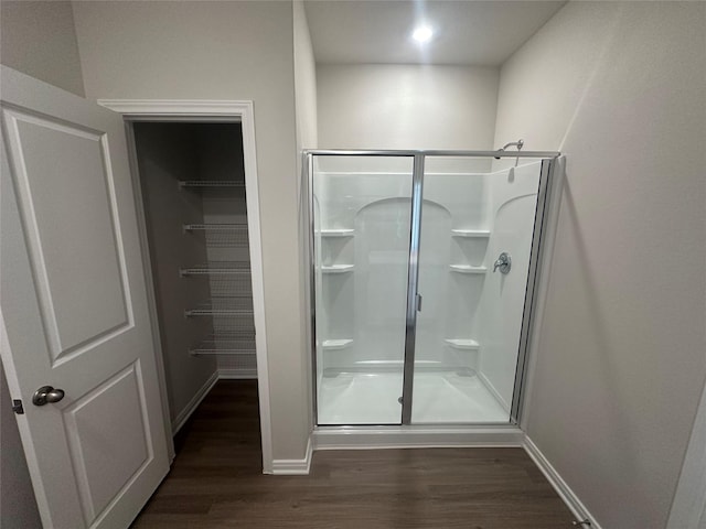 bathroom with hardwood / wood-style floors and an enclosed shower