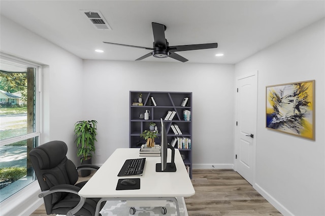 office with light hardwood / wood-style floors and ceiling fan