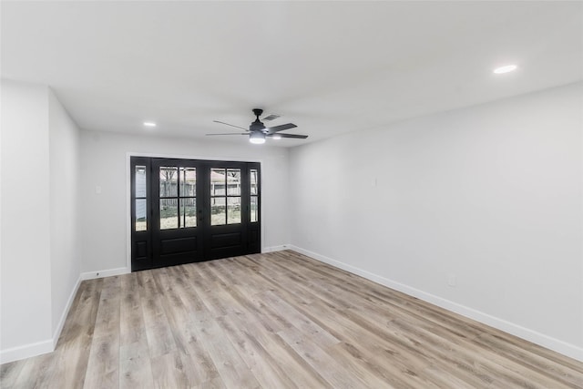 spare room featuring ceiling fan, light wood-type flooring, and french doors