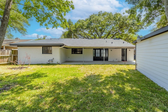 back of house with a yard and a patio