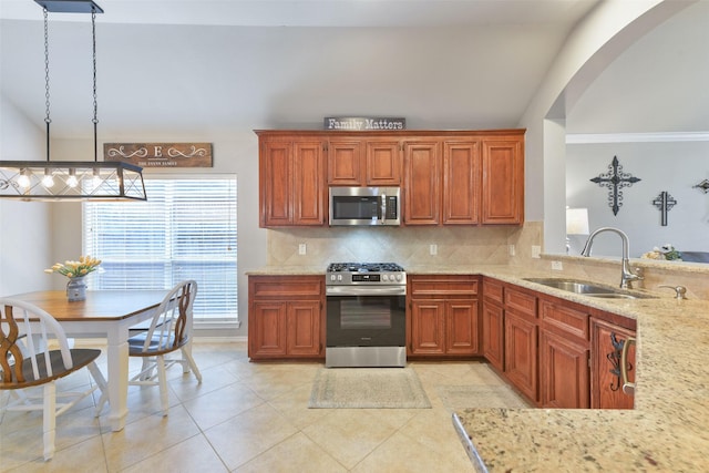 kitchen featuring pendant lighting, lofted ceiling, sink, and appliances with stainless steel finishes