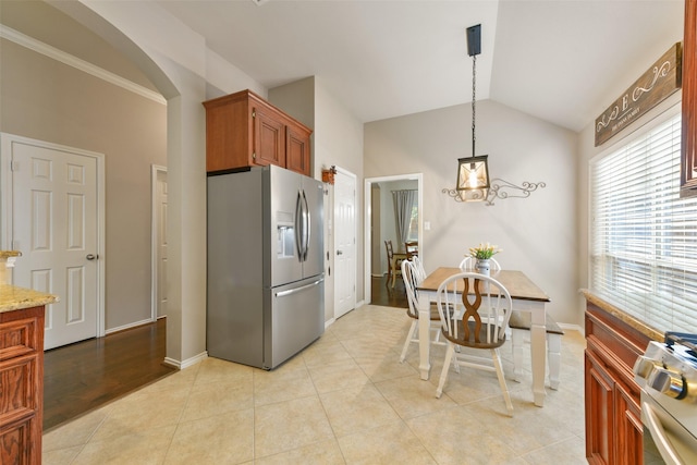 kitchen featuring stainless steel refrigerator with ice dispenser, vaulted ceiling, light tile patterned floors, pendant lighting, and range