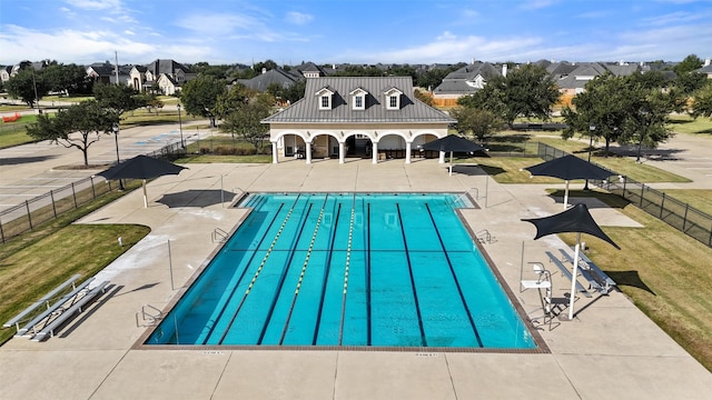 view of swimming pool featuring a lawn and a patio