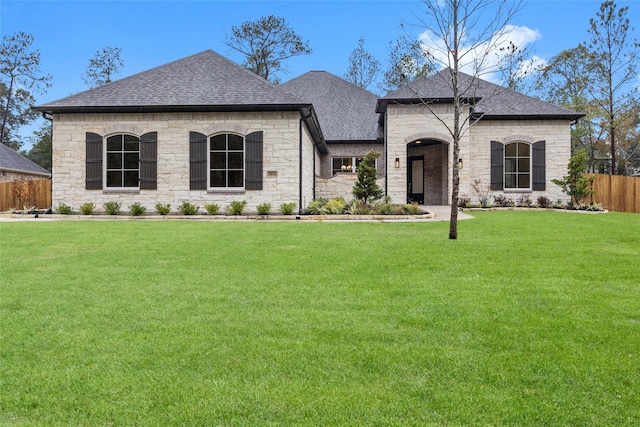 french country inspired facade featuring a front lawn