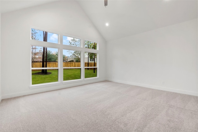 empty room featuring carpet floors and high vaulted ceiling