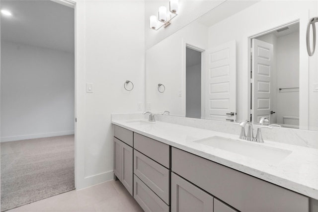 bathroom with tile patterned floors, vanity, a notable chandelier, and toilet