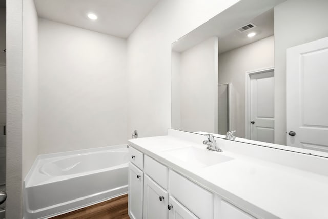 bathroom featuring vanity, independent shower and bath, and hardwood / wood-style flooring