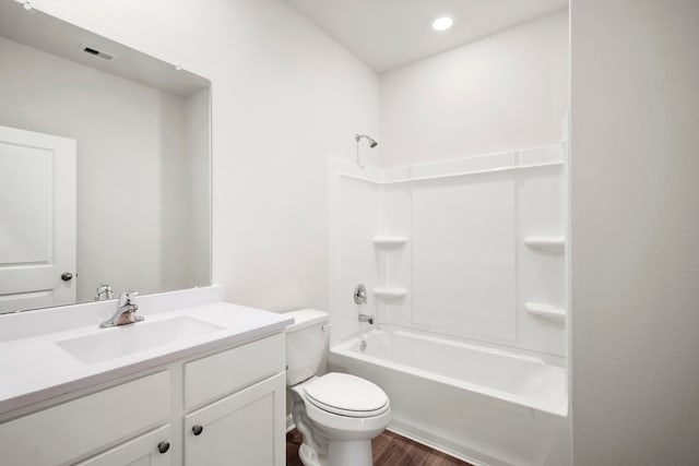 full bathroom with shower / tub combination, vanity, hardwood / wood-style flooring, and toilet