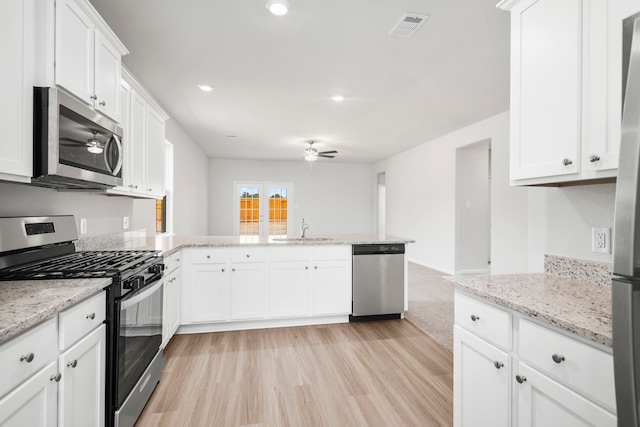 kitchen with kitchen peninsula, sink, ceiling fan, appliances with stainless steel finishes, and white cabinetry