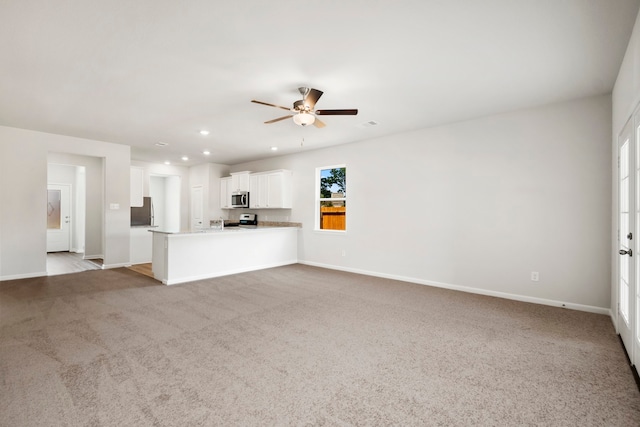 unfurnished living room featuring light carpet and ceiling fan