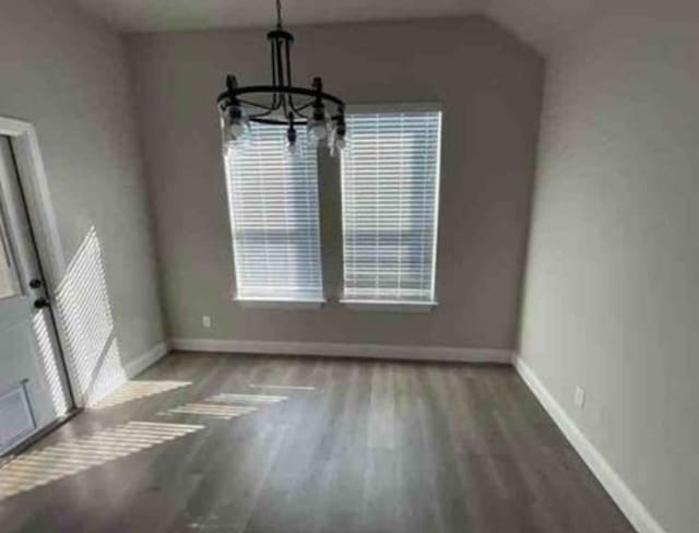 unfurnished dining area with a chandelier, hardwood / wood-style floors, and a healthy amount of sunlight