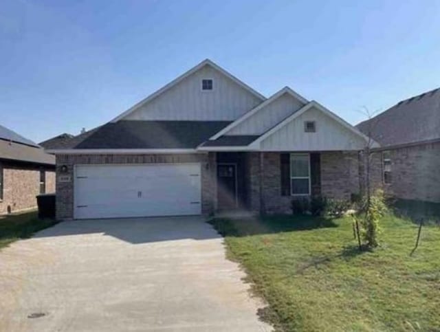 view of front of house featuring a garage and a front lawn