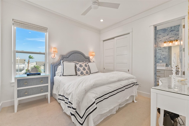 carpeted bedroom with ceiling fan, a closet, and ornamental molding