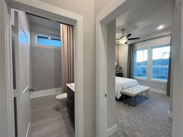 full bathroom featuring ceiling fan, toilet, shower / bath combo with shower curtain, and vanity