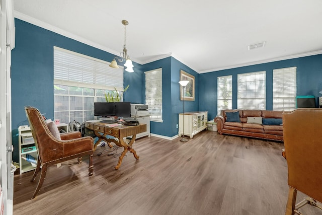 living area featuring hardwood / wood-style flooring, ornamental molding, and a chandelier