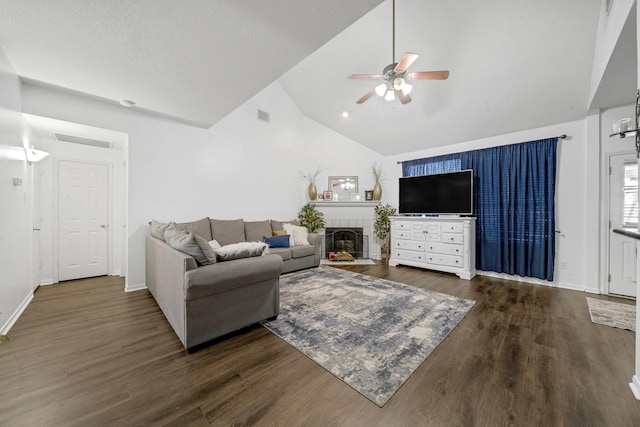 living room featuring a tile fireplace, dark hardwood / wood-style flooring, ceiling fan, and lofted ceiling