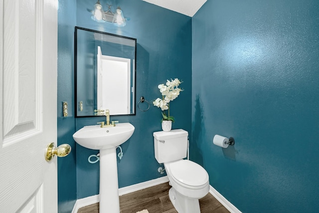 bathroom with hardwood / wood-style flooring, toilet, and sink