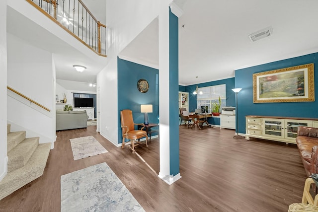 entryway featuring hardwood / wood-style floors, a towering ceiling, and a notable chandelier