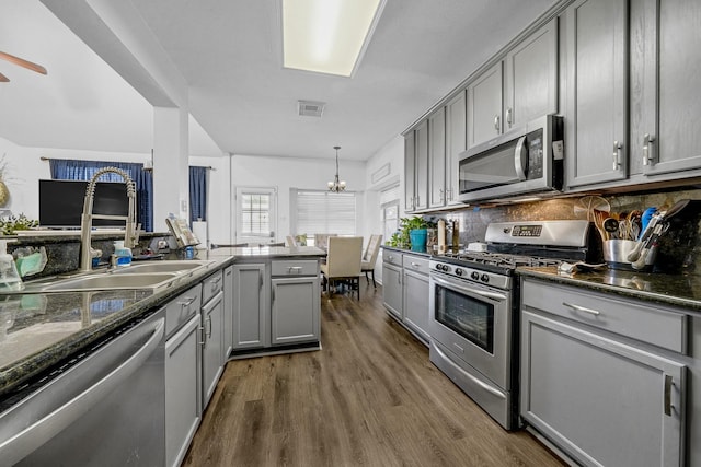 kitchen with gray cabinetry, sink, appliances with stainless steel finishes, tasteful backsplash, and decorative light fixtures