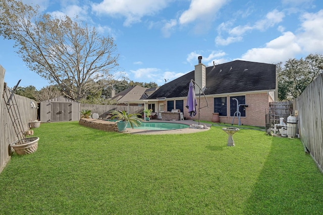 view of yard featuring a fenced in pool and a storage shed