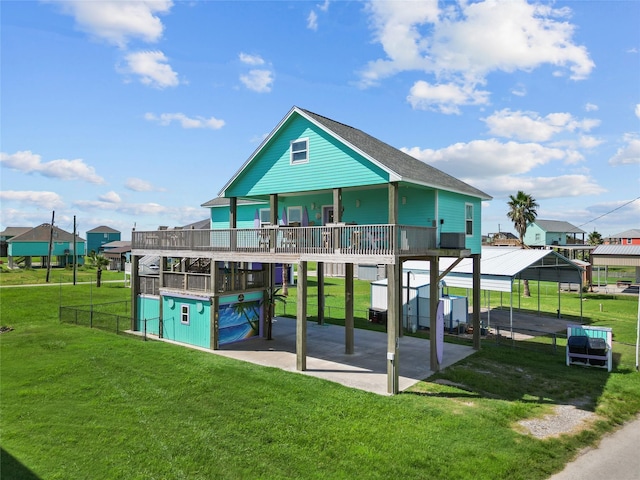 back of property with a carport and a yard