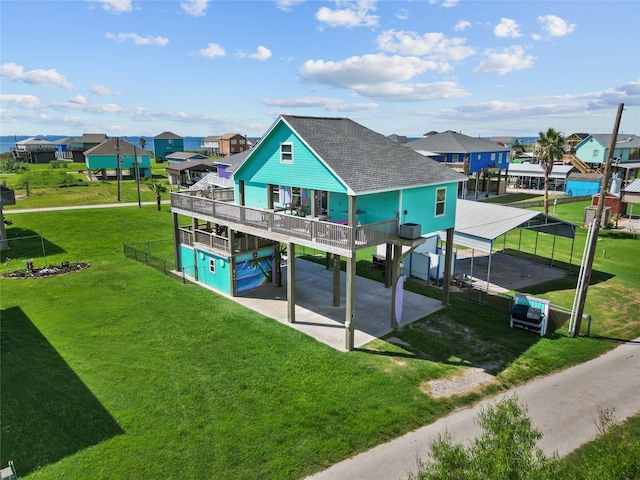 back of property with a wooden deck, a yard, and a carport