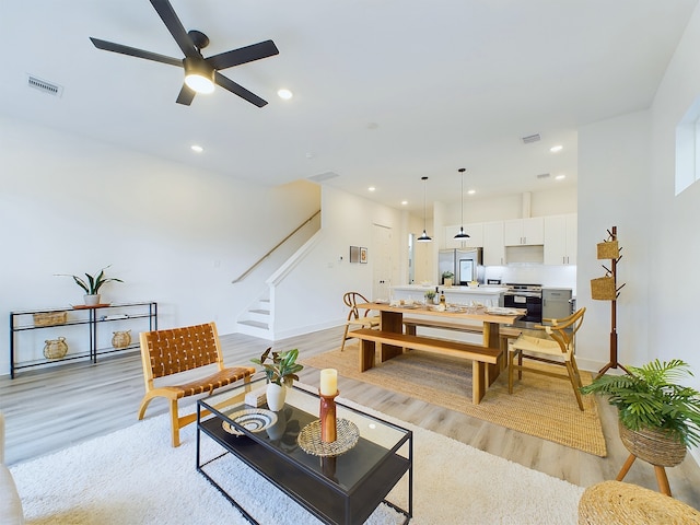 living room with ceiling fan and light wood-type flooring