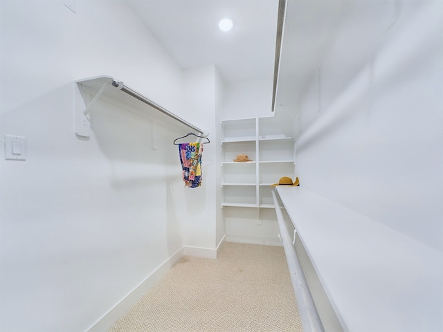 walk in closet featuring light carpet