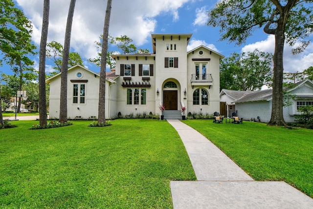 mediterranean / spanish-style home featuring a balcony and a front yard