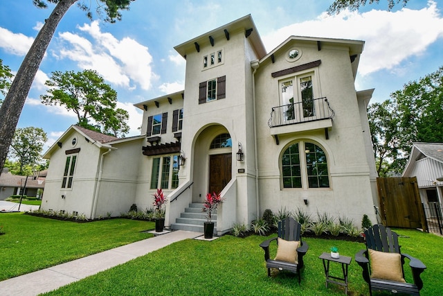 view of front of property featuring a balcony and a front yard