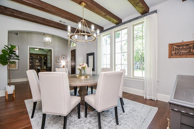 dining room with beamed ceiling, dark hardwood / wood-style flooring, a healthy amount of sunlight, and an inviting chandelier