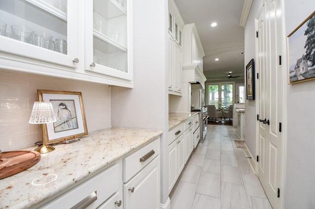 bar featuring tasteful backsplash, white cabinetry, light stone countertops, and electric range