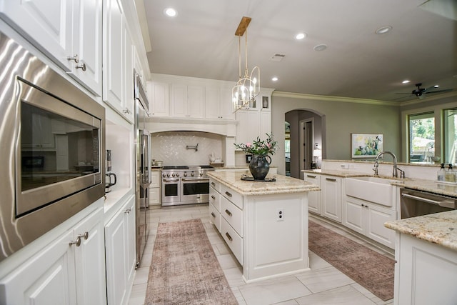 kitchen with light stone countertops, stainless steel appliances, and white cabinets