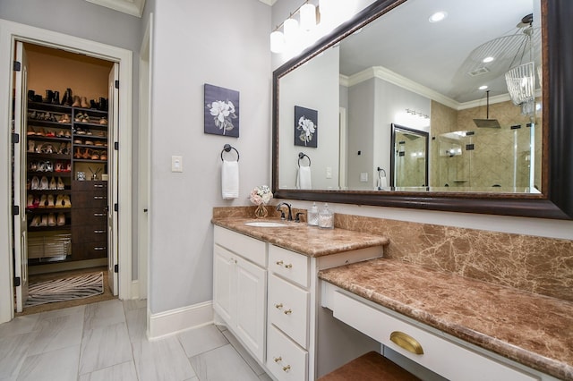 bathroom with a shower with door, vanity, tile patterned floors, and crown molding