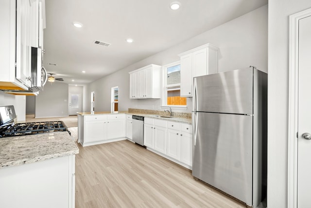 kitchen with kitchen peninsula, stainless steel appliances, white cabinetry, and ceiling fan