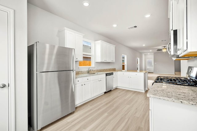 kitchen featuring ceiling fan, white cabinetry, kitchen peninsula, and stainless steel appliances