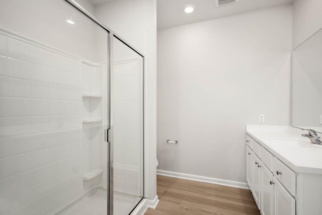 bathroom featuring toilet, a shower with door, vanity, and hardwood / wood-style flooring