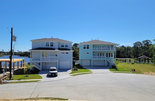 view of front of home featuring a balcony, a front yard, and a garage