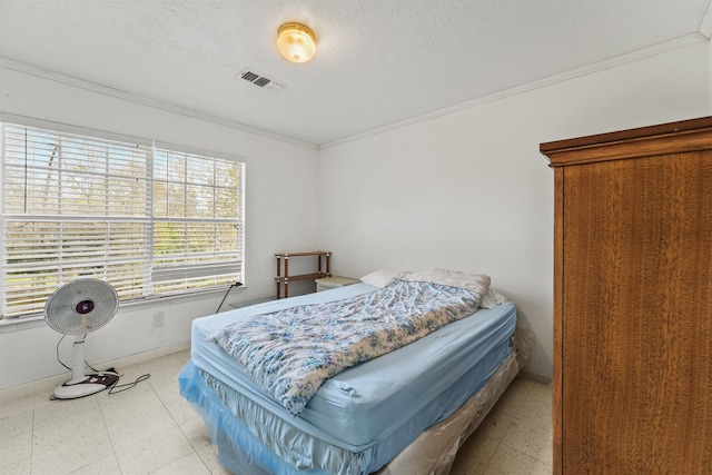 bedroom with a textured ceiling and ornamental molding