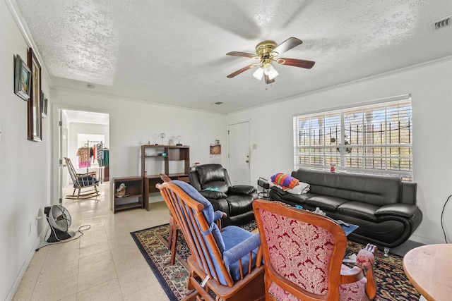 living room with a textured ceiling, ceiling fan, and crown molding