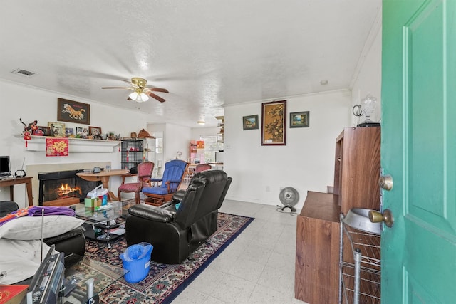 living room featuring a textured ceiling, ceiling fan, and crown molding