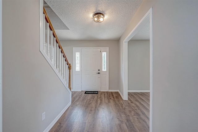 entrance foyer with light hardwood / wood-style floors and a textured ceiling